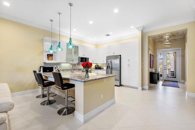 kitchen with appliances with stainless steel finishes, crown molding, and a peninsula