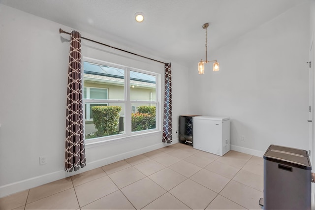 5361 San Benedetto Pl, Fort Pierce, FL 34951 - unfurnished dining area with light tile patterned floors, baseboards, and an inviting chandelier