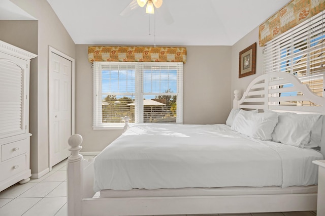 bedroom with light tile patterned floors, a ceiling fan, and baseboards