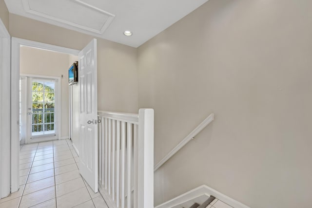 hallway with light tile patterned flooring, recessed lighting, an upstairs landing, baseboards, and attic access