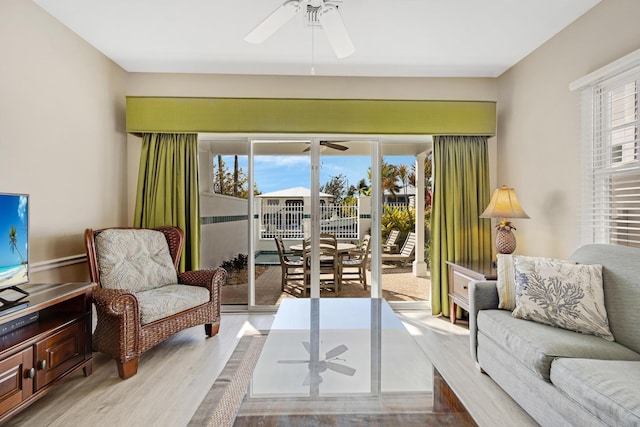 living area featuring light wood-type flooring, plenty of natural light, and ceiling fan