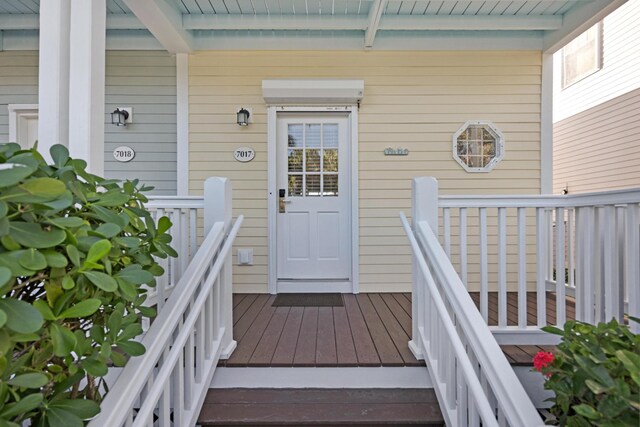 view of exterior entry featuring covered porch