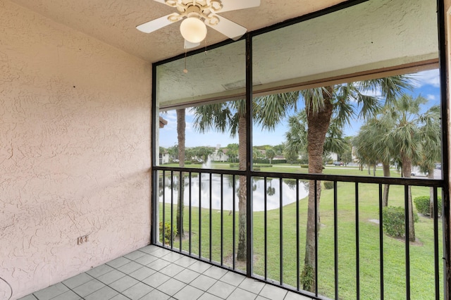 unfurnished sunroom with a water view and a ceiling fan