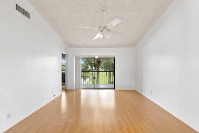 unfurnished room with light wood-style floors, ceiling fan, visible vents, and a textured ceiling