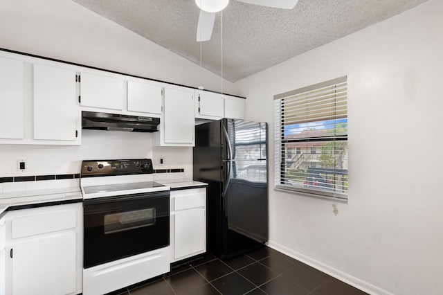 kitchen with under cabinet range hood, dark tile patterned floors, white cabinets, electric stove, and freestanding refrigerator