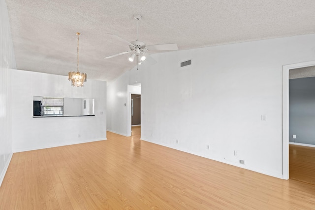 unfurnished living room featuring light wood-style flooring, visible vents, a textured ceiling, and ceiling fan with notable chandelier