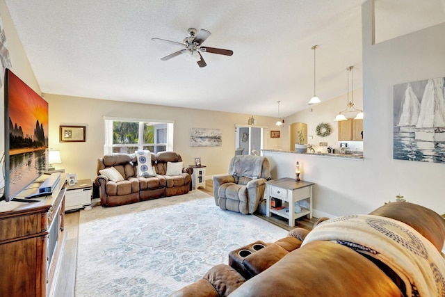 living area featuring ceiling fan, baseboards, vaulted ceiling, and wood finished floors