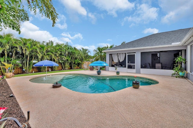 view of swimming pool featuring a sunroom, a fenced backyard, a patio area, and a fenced in pool