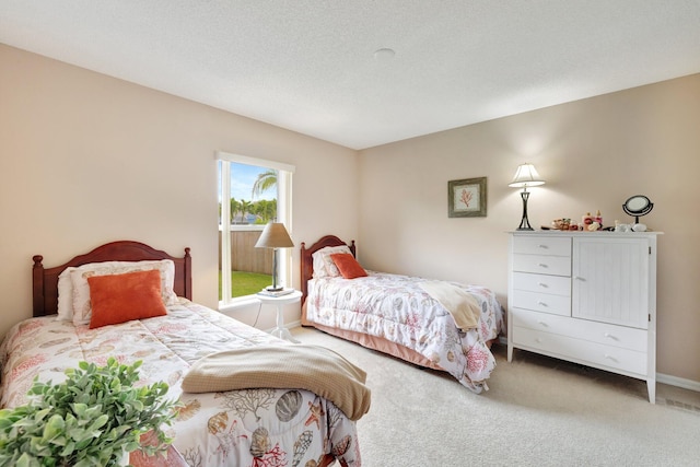 bedroom featuring a textured ceiling, baseboards, and carpet flooring