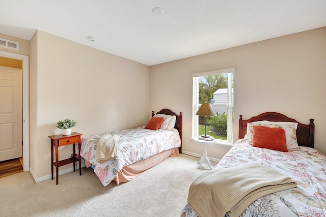 carpeted bedroom featuring baseboards and visible vents