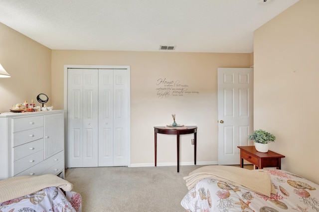 bedroom with baseboards, visible vents, a closet, and light colored carpet