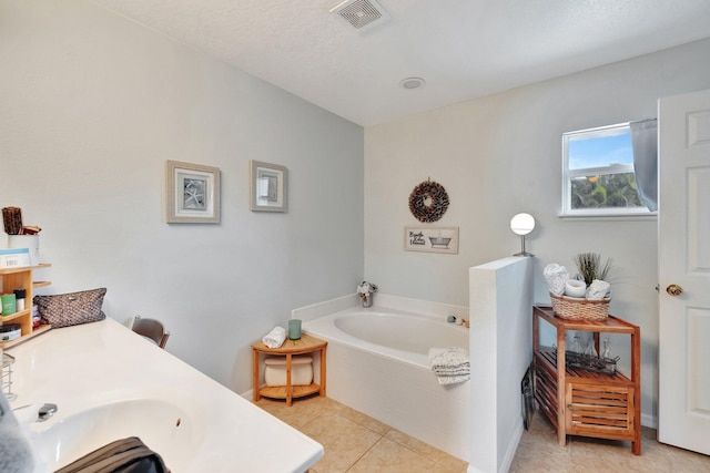 full bath featuring a garden tub, visible vents, a sink, and tile patterned floors