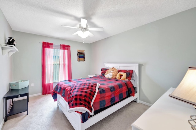 bedroom featuring baseboards, a textured ceiling, and light colored carpet