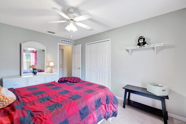 bedroom featuring a ceiling fan, visible vents, and light carpet