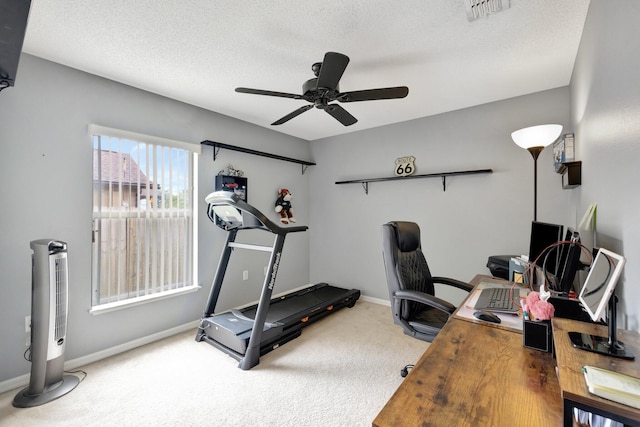 interior space with a textured ceiling, carpet floors, visible vents, baseboards, and a ceiling fan