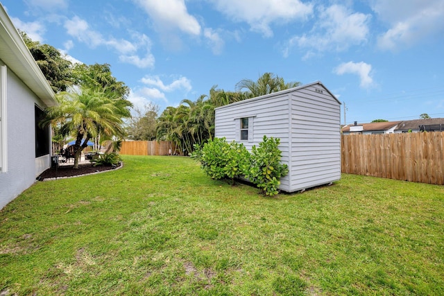 view of yard featuring an outbuilding, a storage unit, and a fenced backyard