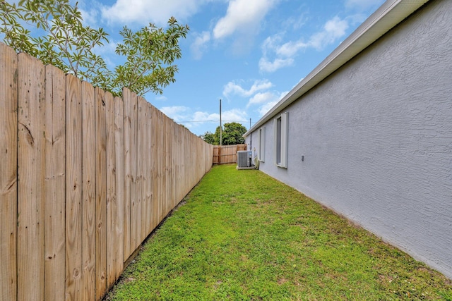 view of yard featuring central AC unit and a fenced backyard