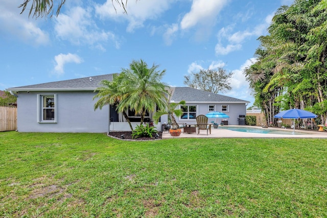 rear view of house with a patio, a yard, fence, and a fenced in pool