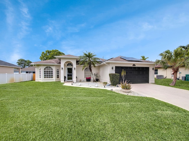 view of front of home featuring driveway, a garage, solar panels, a front lawn, and stucco siding