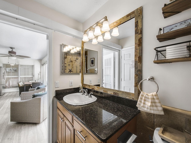 bathroom with a ceiling fan, vanity, and wood finished floors