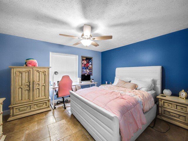 bedroom featuring ceiling fan, a textured ceiling, and stone tile flooring