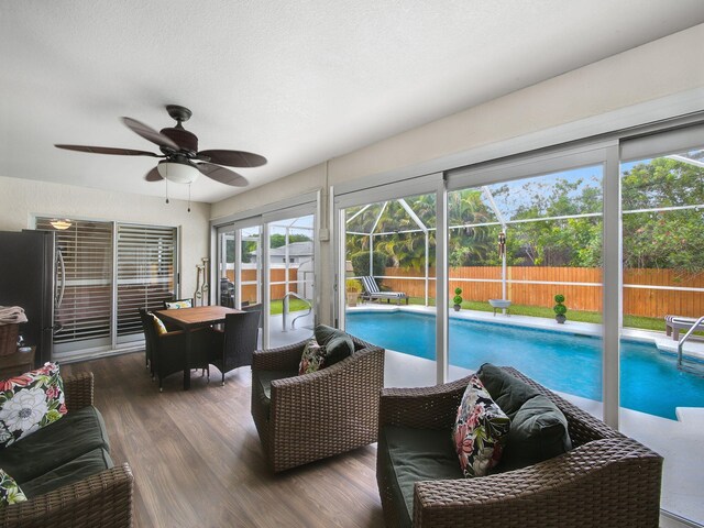 sunroom / solarium featuring a ceiling fan