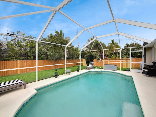 view of pool with a patio, glass enclosure, a fenced backyard, a yard, and a fenced in pool