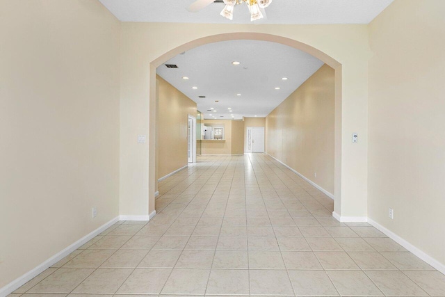 corridor with recessed lighting, visible vents, arched walkways, and light tile patterned floors