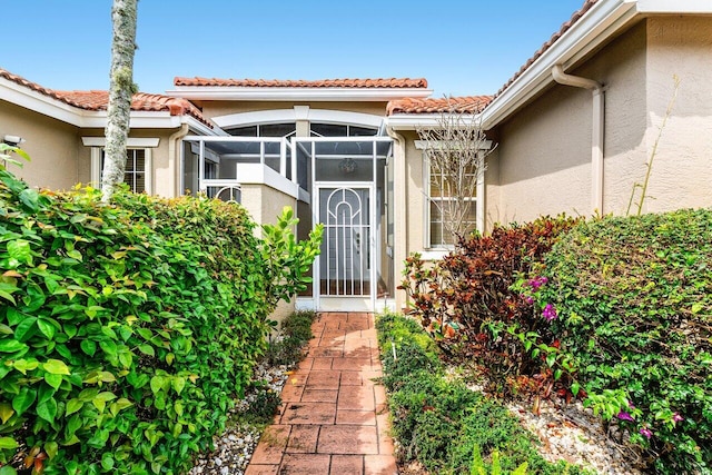 property entrance with stucco siding and a tiled roof