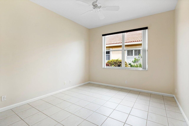 unfurnished room with light tile patterned flooring, baseboards, and ceiling fan