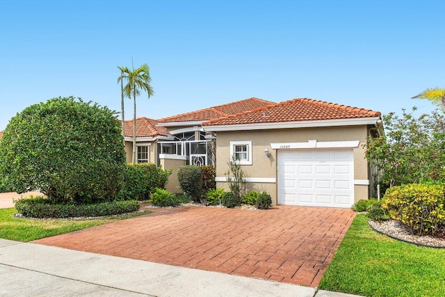 view of front of home featuring stucco siding, decorative driveway, a garage, and a tile roof