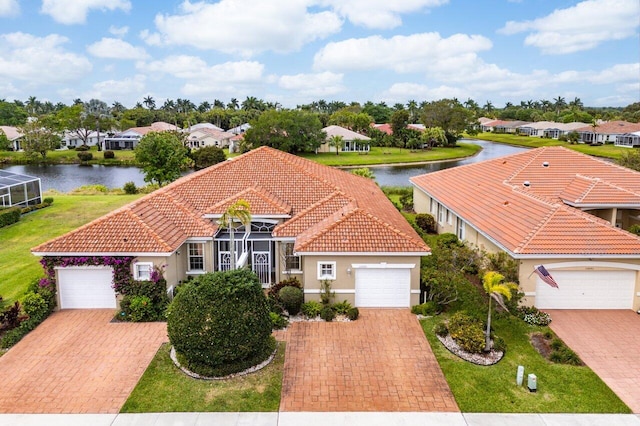 view of front of home featuring stucco siding, a water view, and a tiled roof