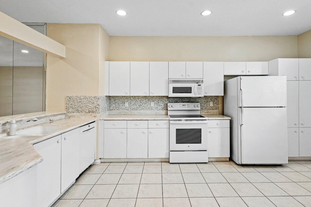 kitchen featuring white cabinetry, white appliances, light countertops, and a sink