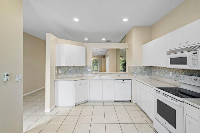 kitchen with light countertops, light tile patterned floors, decorative backsplash, white appliances, and white cabinetry