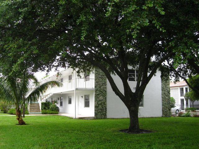 view of side of home featuring a yard, a balcony, and stucco siding