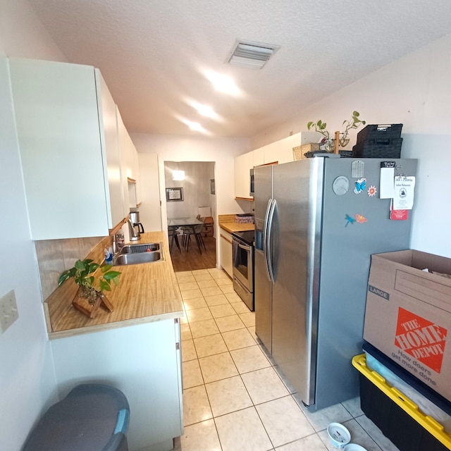 5070 Nesting Way Unit B, Delray Beach, FL 33484 - kitchen featuring light tile patterned floors, visible vents, stainless steel appliances, a sink, and light countertops