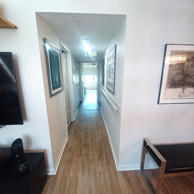 5070 Nesting Way Unit B, Delray Beach, FL 33484 - hall featuring baseboards, a textured ceiling, and wood finished floors
