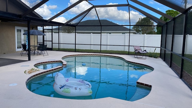 view of pool with a patio area, a lanai, a fenced backyard, and a pool with connected hot tub