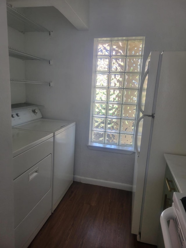 clothes washing area with laundry area, baseboards, dark wood-style floors, and washer and dryer