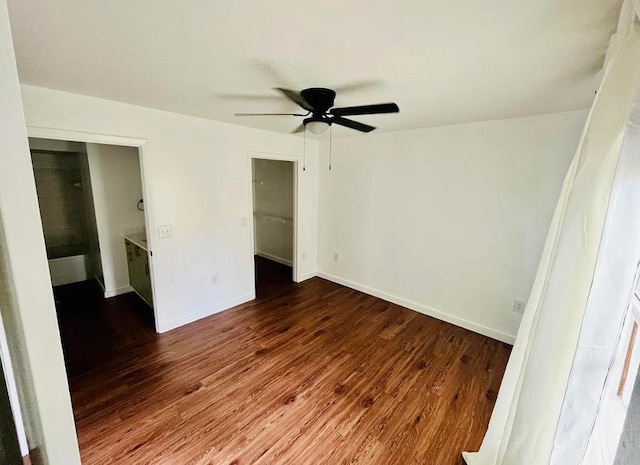 unfurnished bedroom with dark wood-type flooring, ceiling fan, and baseboards