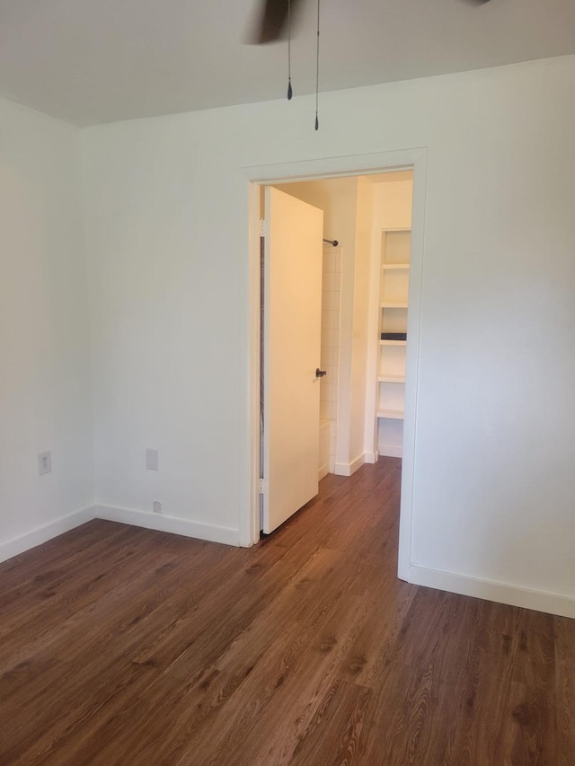 empty room featuring dark wood finished floors and baseboards