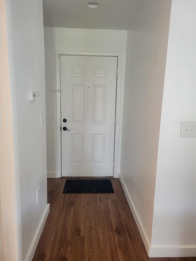 doorway to outside with dark wood-type flooring and baseboards