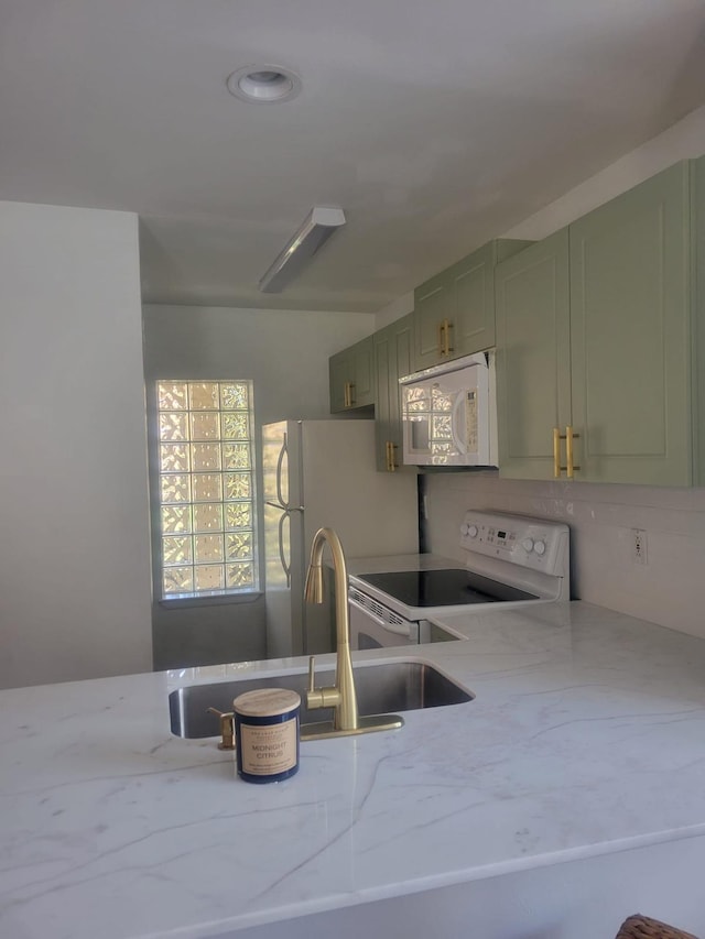 kitchen featuring light stone countertops, white appliances, and green cabinetry