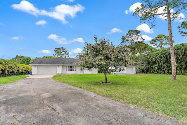 ranch-style home featuring a front yard, driveway, and an attached garage