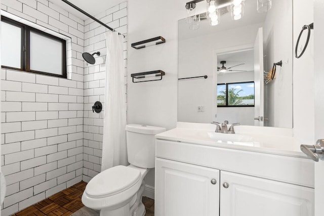 full bath with vanity, a tile shower, and toilet