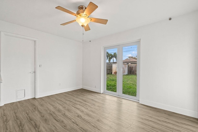 spare room featuring a ceiling fan, baseboards, and wood finished floors