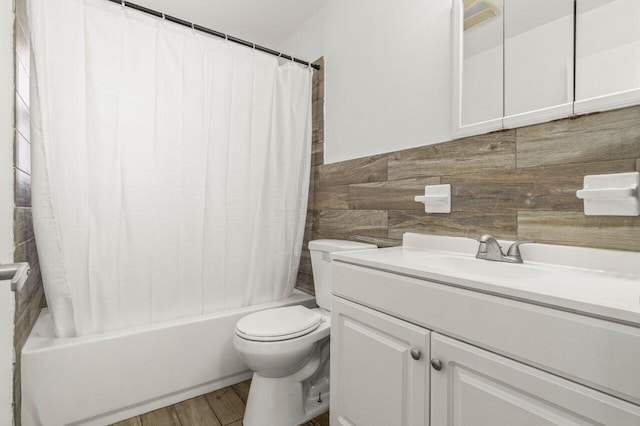 full bathroom featuring toilet, wood finished floors, vanity, tile walls, and shower / bath combo