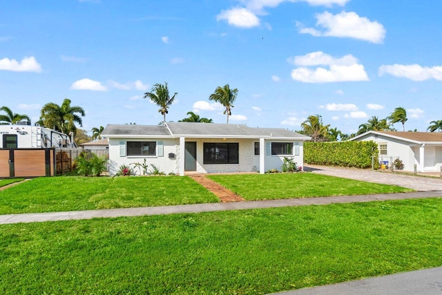 ranch-style home with a front yard and fence