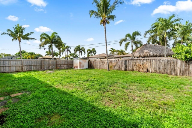 view of yard featuring a storage shed, an outdoor structure, and a fenced backyard