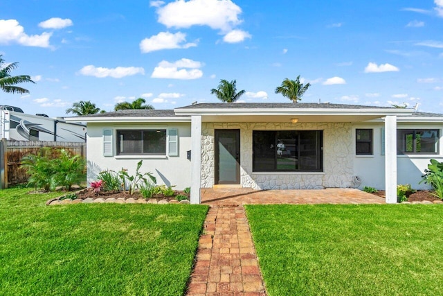 view of front of house with a front yard, fence, and stucco siding